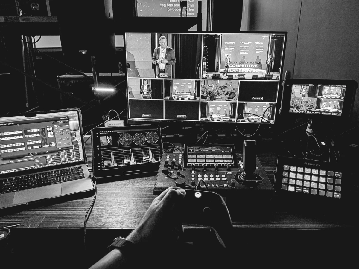 Switcher and video monitors showing a live presentation